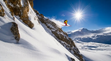 Skieur engagé qui saute une barre rocheuse