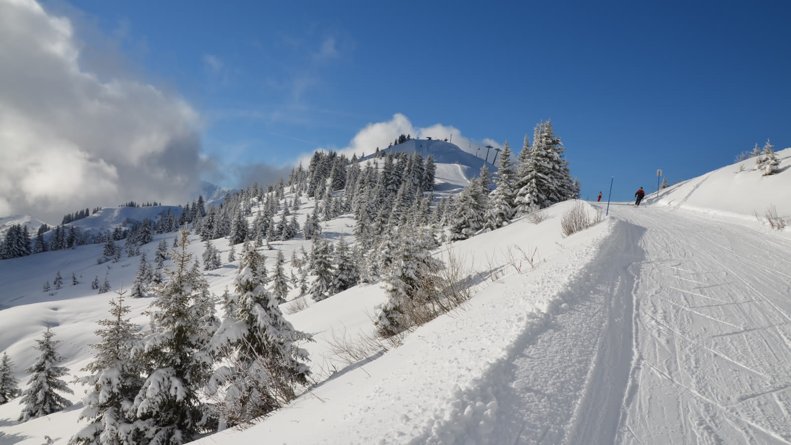Skieurs sur la piste bleue La Controverse, sur le domaine skiable Les Portes du Mont-Blanc