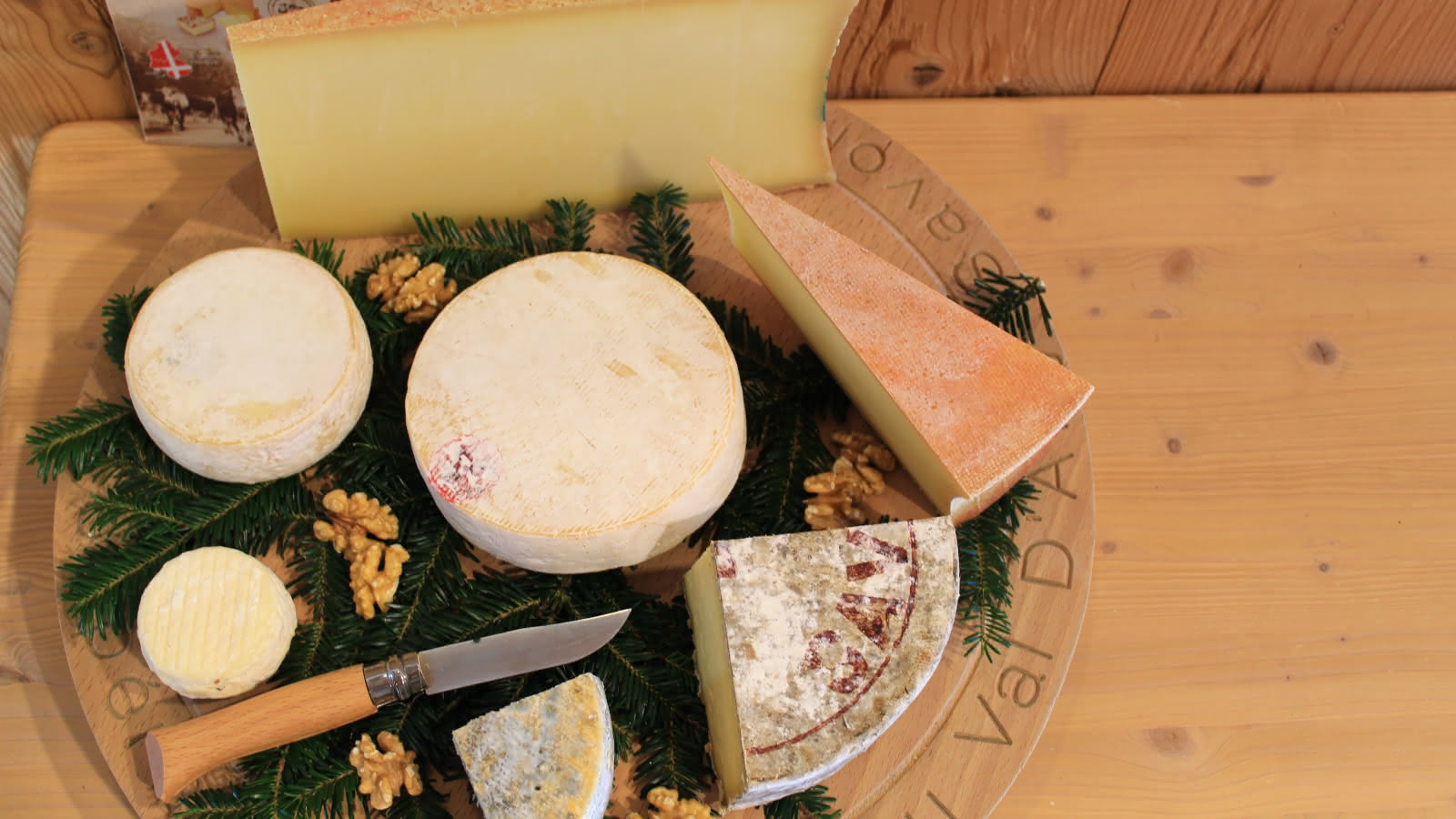 Plateau de divers fromages vu de dessus, posé sur une table en bois.