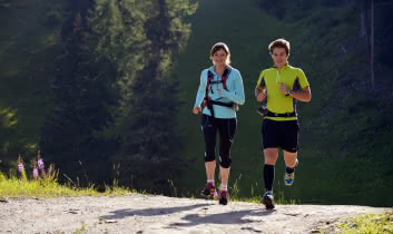 Deux traileurs sont en train de courir sur un large sentier aux abords de la forêt de Sainte Foy Station