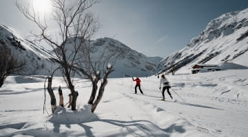 Ski de fond dans la magnifique vallée du Manchet à Val d'Isère avec deux personnes en arrière plan