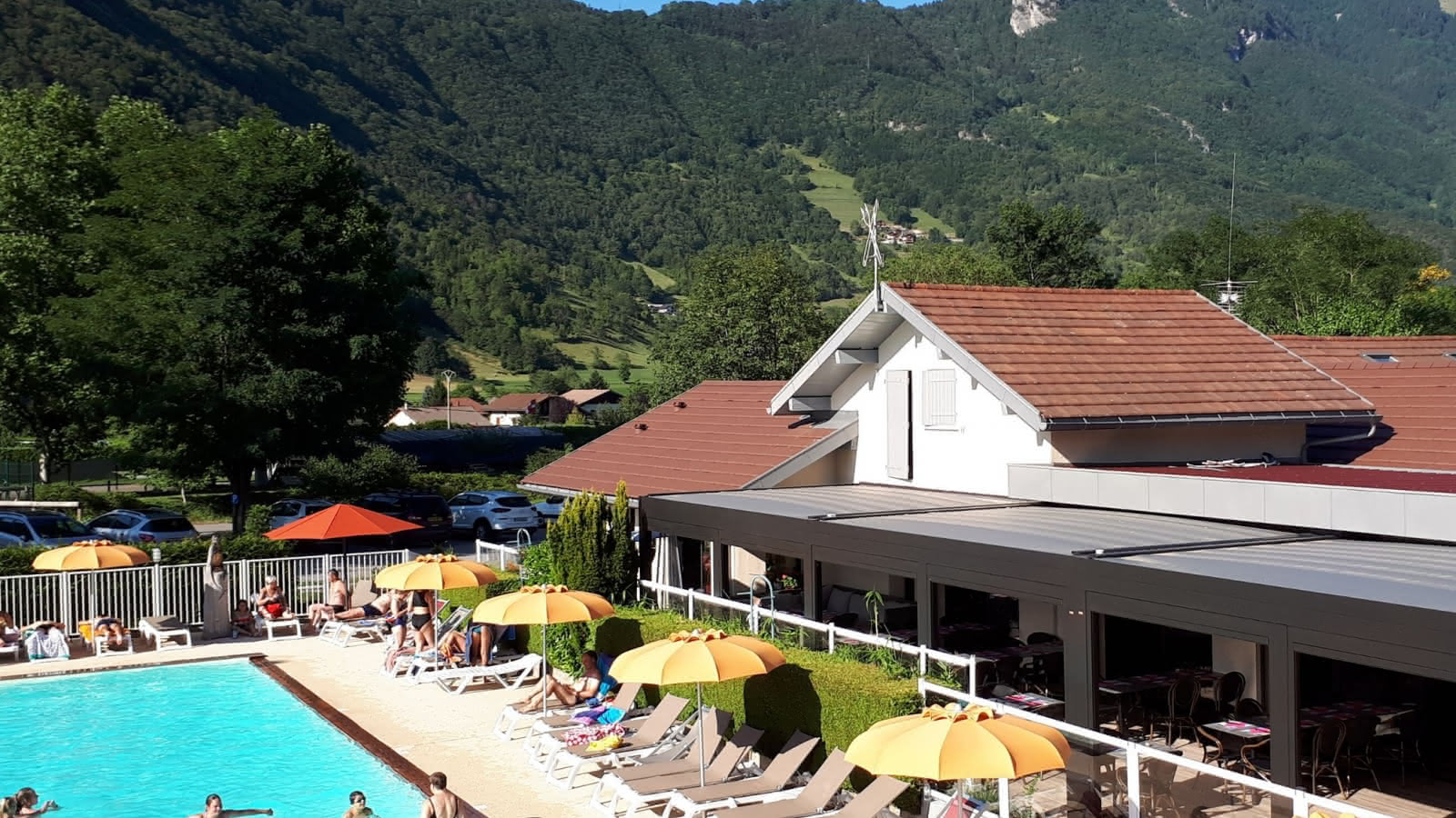 pool deckchairs and restaurant with mountain view