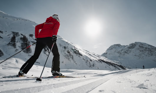 Ski de fond dans la magnifique vallée du Manchet à Val d'Isère avec un personne sur les pistes de fond et un grand soleil