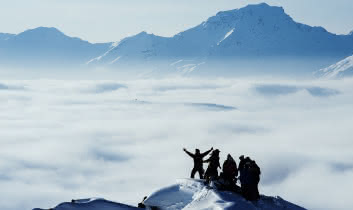 Un groupe de randonneurs est au sommet au dessus d'une mer de nuage dans les 3 vallées